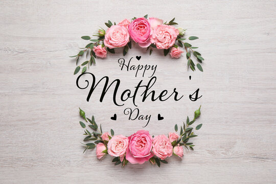 happy mother's day. greeting card with frame of beautiful flowers on white wooden background, flat l
