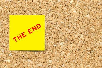 Sticker - Yellow note paper with word the end on cork board background with copy space