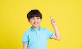 portrait of an asian boy posing on a yellow background