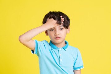 portrait of an asian boy posing on a yellow background