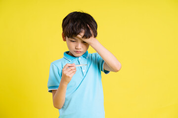 Poster - portrait of an asian boy posing on a yellow background