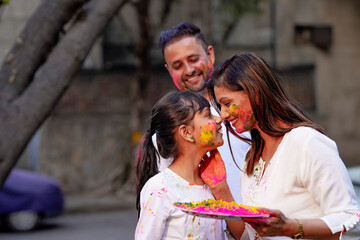 Wall Mural - young indian family celebrating holi festival