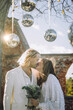 © Maskot - Newly married couple kissing on mouth under disco balls at wedding