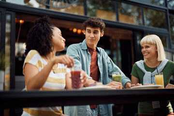 Wall Mural - Young happy people talk while gathering in cafe.