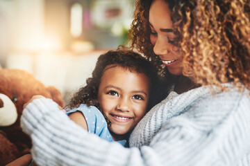 Wall Mural - Mom hugs, nothing quite like them. Shot of an adorable little girl and her mother in a warm embrace at home.