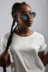 Wall Mural - Cool Female Model With Braided Hair and Sunglasses Over Gray Background