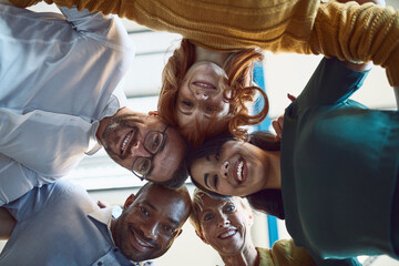 Canvas Print - Surrounded by like minded go getters. Low angle shot of a group of colleagues huddled together in solidarity at work.