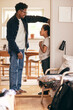 © Maskot - Father measuring height of son standing at doorway of home