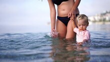 Mom And A Little Girl Are Standing In The Sea On The Shallows Holding Hands
