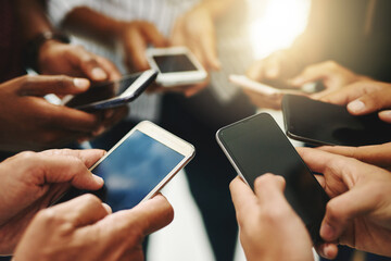 Poster - Were all connected. Closeup shot of a group of unrecognizable businesspeople using their cellphones in synchronicity.