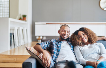 Poster - Quality time comes first in our marriage. Portrait of a happy young couple relaxing together on the sofa at home.