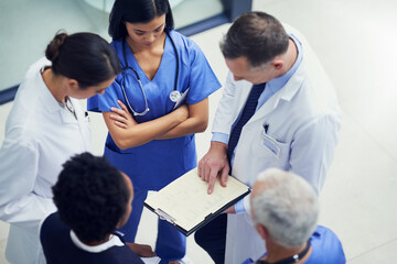 Aufkleber - Lets up the dosage for this patient. Shot of a group of doctors talking together over a medical chart while standing in a hospital.