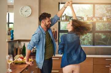 Poster - Spontaneous dancing and romancing. Shot of a happy young couple dancing together at home.