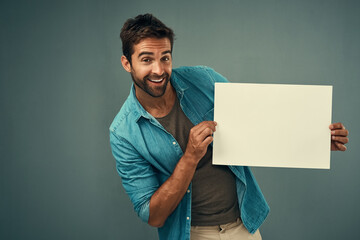 Poster - If youve got a concept to sell, place it here. Studio portrait of a handsome young man holding a blank placard against a grey background.