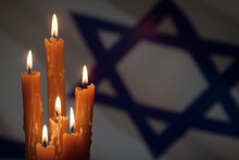 Six Burning Candles On Israel Flag Background. International Holocaust Remembrance Day, January 27.