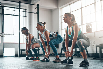 Poster - its not meant to be easy. shot of three young women working out together.