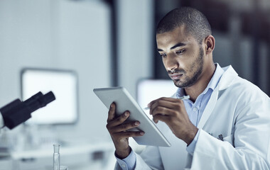 Poster - Taking advantage of electronical information. Shot of a scientist recording his findings on a digital tablet.