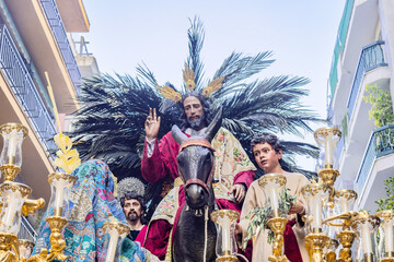 christ riding a donkey in the throne or platform of the brotherhood of the la borriquita, in process