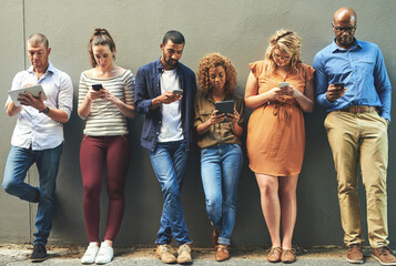 Poster - Social networking helps reach people easier and quicker. Shot of a diverse group of people social networking outside.