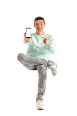 Canvas Print - Handsome guy pointing at mobile phone in chair on white background