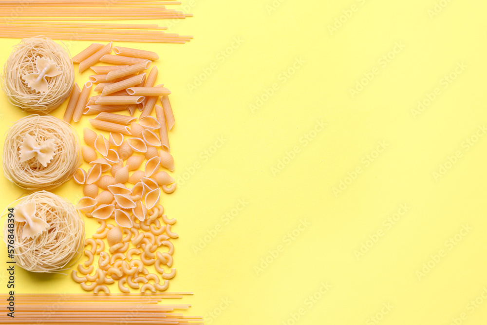 Different types of raw pasta on yellow background