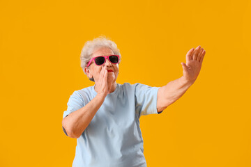 Sticker - Senior woman in sunglasses on yellow background