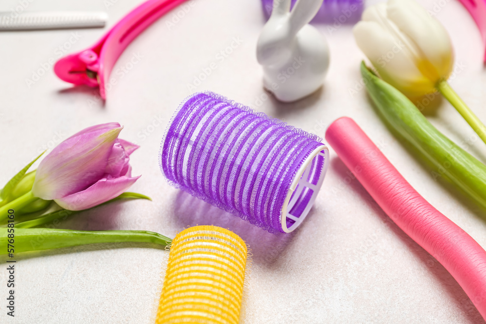Curlers with Easter rabbit and tulips on white background, closeup