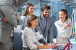 © Bojan - Large group of confidence business people laughing while checking successful project on computer together in modern glass office.