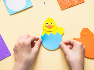 Hands of a caucasian teenage girl sticking a sticker of a blue shell with a zigzag