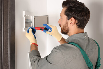 Poster - Electrician installing fuse box with screwdriver indoors