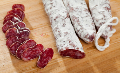 Wall Mural - Sliced Catalan sausage Fuet on wooden background