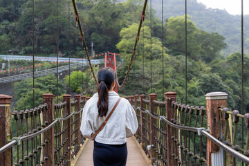 Poster - Woman stepping onto the suspension bridge in Wulai of Taiwan