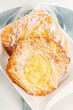 Fresh baked apple and custard danish topped with white fondant and icing sugar.