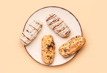 Wall Mural - Plate with delicious eclairs on beige background