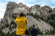 Tourists taking pictures and observe mountain Rushmor with USA presidents sculptures