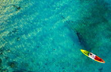 Aerial View Of A Kayak In The Blue Sea .Woman Kayaking She Does Water Sports Activities.