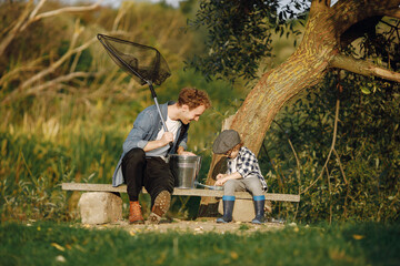 Wall Mural - Young father teaching his little toddler son how to fish