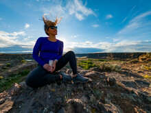 Athletic Adventurous Female Hiker Sitting On A Ridge With Her Hair Blowing In The Wind, Overlooking A Beautiful Valley In Eastern Washington Along The Columbia River.

