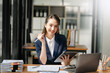 © Nuttapong punna - Young attractive Asian female office worker business suits smiling at camera in office