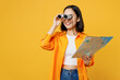© ViDi Studio - Young happy woman wear summer casual clothes hold in hand map use binoculars isolated on plain yellow background. Tourist travel abroad in free spare time rest getaway Air flight trip journey concept.