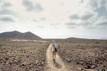 Man Walking On Dirt Path In Desert