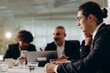 © CinemaF - Business meeting of business partners in the office. A young businessman sits at a table together with partners on a blurred background.