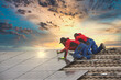 © mmphoto - Installing solar photovoltaic panel system. Solar panel technician installing solar panels on roof. Alternative energy ecological concept.