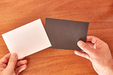 The man is holding two sheets of paper, black and white. Banner for advertising.