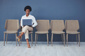 Black woman, laptop and focus for interview on chair with email, waiting and ready for job opportunity. Young african businesswoman, recruitment and mockup with computer for typing, research and goal