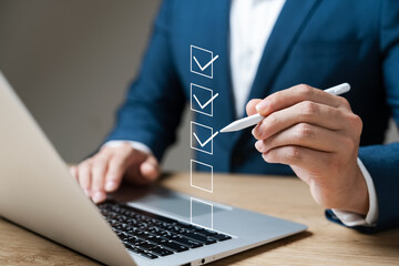 business performance checklist concept, businessman using laptop doing online checklist survey, fill