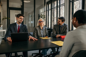 Wall Mural - Female candidate talk to human resource team while giving them application forms on a job interview in the office.