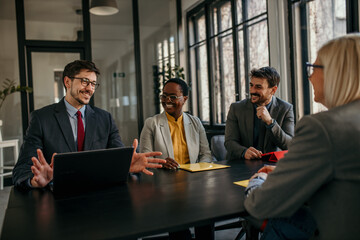 Wall Mural - A black woman accompanied by two men sitting in the board room and having a business interview with a new candidate.