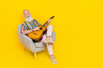 Sticker - Full body portrait of positive handsome man playing guitar singing empty space isolated on yellow color background