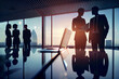 © xartproduction - Silhouettes of businessmen in the office against the background of panoramic windows and glare of sunlight